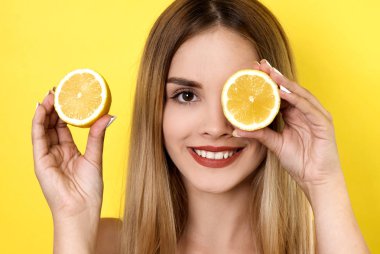Limon dilimleriyle poz veren genç bir kadın.