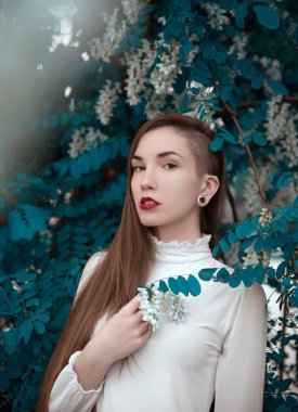 Çiçek açan ağacın yanında güzel genç kadının portresi 