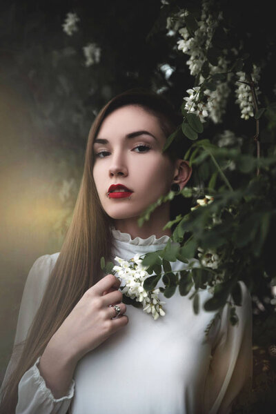 Portrait of beautiful young woman beside blooming tree 