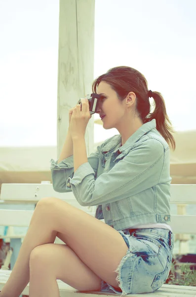 Side view of beautiful woman with retro camera