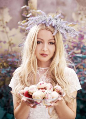 Paskalya yumurtalarıyla poz veren genç kadının portresi 