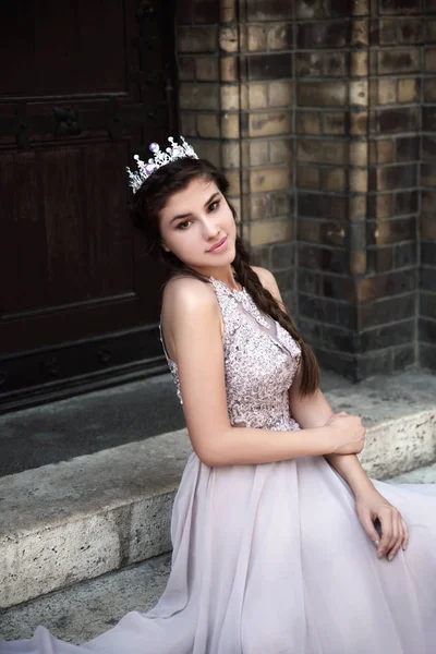 Portrait of young woman in crown posing