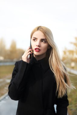 parkta akıllı telefonda konuşan genç kadın 