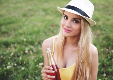 Parkta şişe tutan genç bir kadın. 