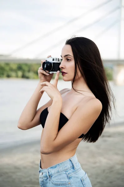ビーチでヴィンテージカメラを使う若い女性は — ストック写真