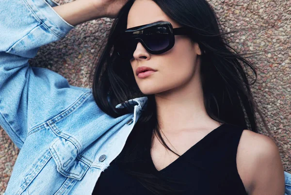 Poz güneş gözlüklü genç kadın portresi