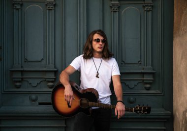 Gitarlı yakışıklı bir genç.  