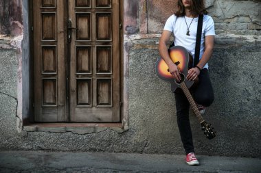 Gitarlı yakışıklı bir genç.  