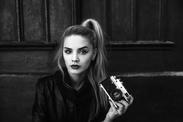 Young beautiful woman holding vintage camera