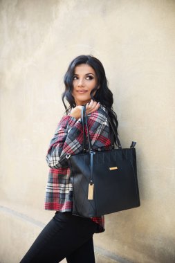 Genç ve güzel bir kadın şehirde poz veriyor. 