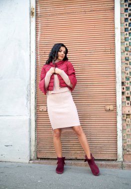 Genç ve güzel bir kadın şehirde poz veriyor. 