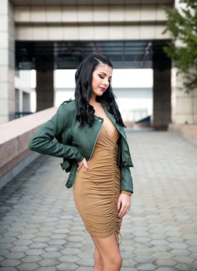 Genç ve güzel bir kadın şehirde poz veriyor. 