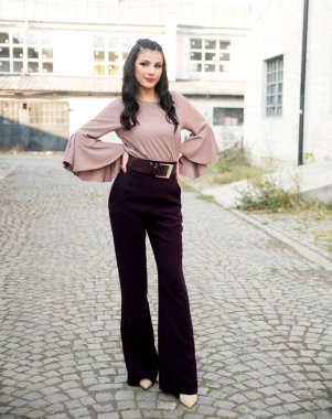 Genç ve güzel bir kadın şehirde poz veriyor. 