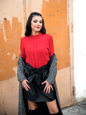 Genç ve güzel bir kadın şehirde poz veriyor. 