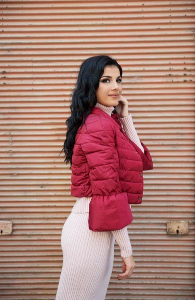 Genç ve güzel bir kadın şehirde poz veriyor. 