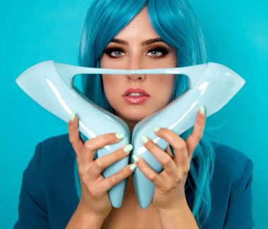 Mavi saçlı ayakkabı tutan güzel genç kadın portresi 