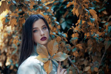 Yaprakla poz veren güzel bir kadın. 