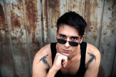 Güneş gözlüklü genç adamın portresi.