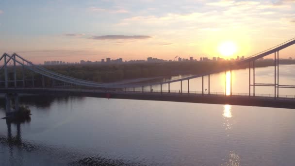 空中日の出にキエフの歩行者専用橋を撮影します キエフ Dniepeer 川で夏の朝 ウクライナ ヨーロッパの都市 — ストック動画