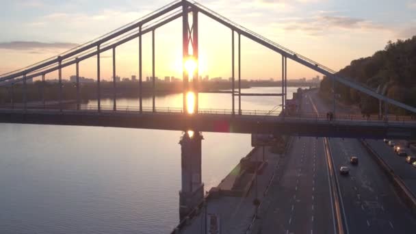 空中日の出にキエフの歩行者専用橋を撮影します キエフ Dniepeer 川で夏の朝 ウクライナ ヨーロッパの都市 — ストック動画