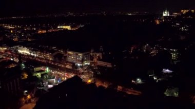 Havadan çekim gece şehir, çatılar, sokaklarda gece trafik ışıkları ile