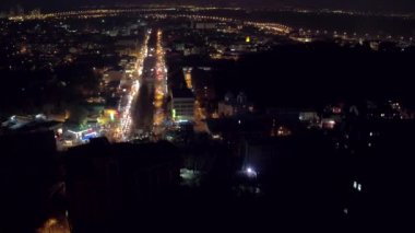 Havadan çekim gece şehir, çatılar, sokaklarda gece trafik ışıkları ile