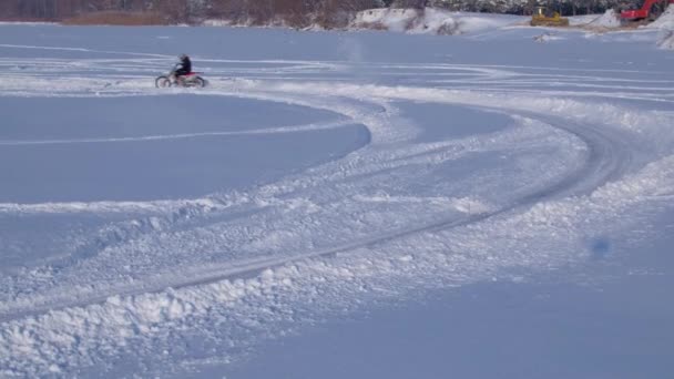 雪に覆われたモトクロス トラックにバイク ライダー 雪の上の ライダー バイク モトクロス冬シーズンのレースのモトクロス ライダー レーサー バイクに乗って冬の雪に覆われたモトクロス — ストック動画