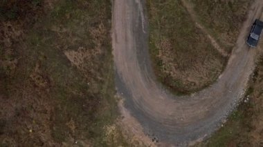 Hava üstten görünüm bir araba ile sıkı virajlı küçük yolda gidiyor. Havadan görünümü eski siyah bmw sıkı kıvrımları ile ülke yolda gidiyor
