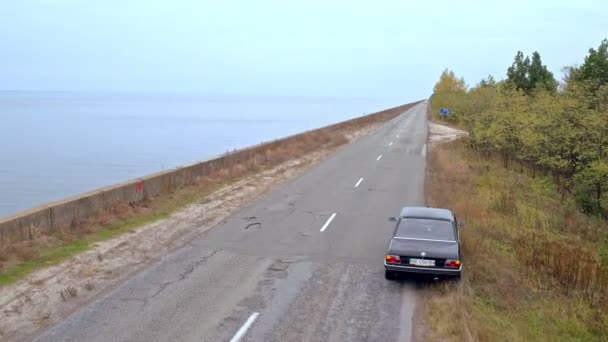 海辺に行く車の空中撮影 散歩古い黒 Bmwalongthe 海岸の空撮 — ストック動画