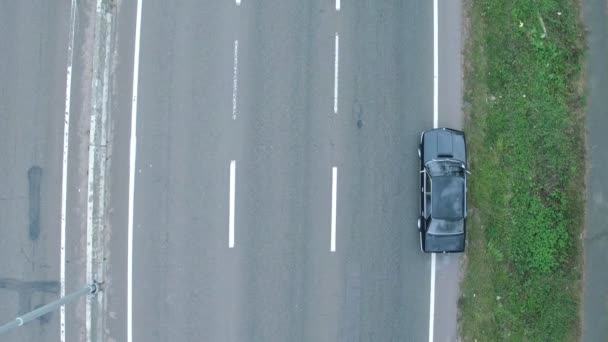 Letecké fotografování z vozu, což je na dálnici. Letecký pohled na retro černé bmw, kteráje na dálnici