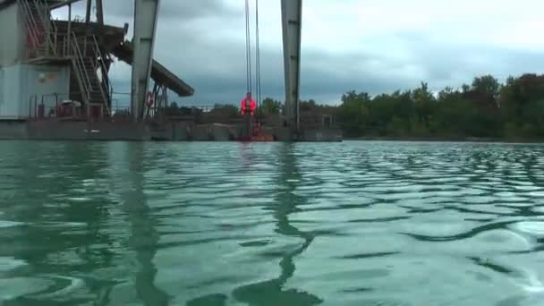 湖の底から小石の抽出のためのインストールをフローティング — ストック動画
