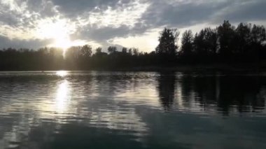 Sonbahar. Yumuşak günbatımı. Güneşin göl yansımasıdır. Ördekler havaya uçmak.
