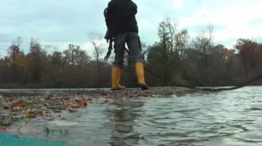 Göl. Adası. Bir adam bir gemiden kıyıya atlar..