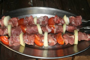 Marine domuz şaşlık domates dilimleri ve soğan halkası ile üç şiş üzerinde yaklaşık ızgara etmektir