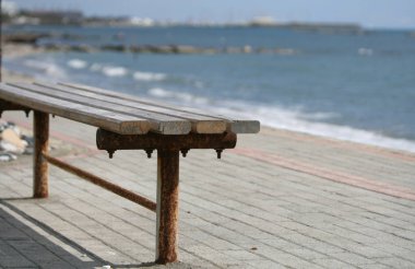 Boş bir eski ahşap Bank güneşli bir deniz kenarında bir taş kaldırımda Close-Up