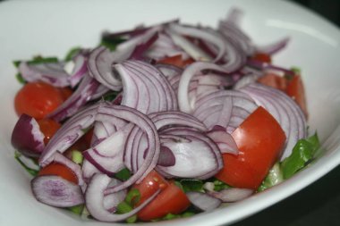 Close-Up bir domates taze sebze salatası, beyaz bir plaka üzerinde kırmızı ve yeşil soğan