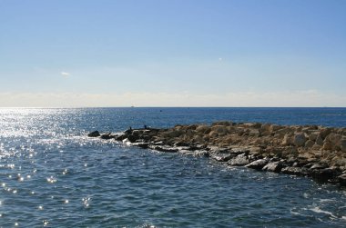 Panoramik parlak Akdeniz ve açık mavi gökyüzü taş pier yakınındaki 