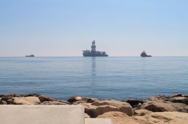 Güneşli bir bahar gününde Limasol Molos gezinti yolunun bir sahil yolunun ufukta üç gemi ile Akdeniz manzarası