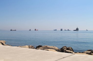 Güneşli bir bahar gününde Limasol Molos gezinti yolunun bir sahil yolunun ufukta birkaç gemi ile Akdeniz manzarası