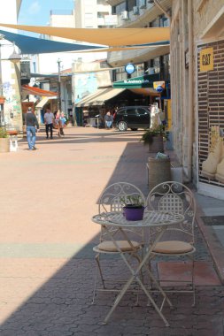Limasol, Kıbrıs, 22 Mart, 2019: retro tarzı metal masa ve iki sandalye bir güneşli bir gün Limasol eski kasabasında bir turist sokakta bir gölge ayakta