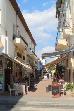 Limasol, Kıbrıs, 22 Mart, 2019: güneşli bir günde Limasol eski kentinde dar bir turist sokakta insanlar yeme ile küçük kafe