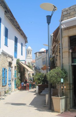 Limasol, Kıbrıs, 12 Nisan 2019: Eski kentte geleneksel evler ve küçük bir kaldırım kafesi ile dar yaya caddesi