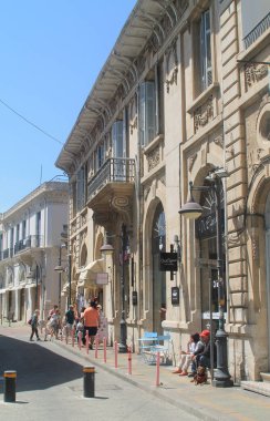 Limasol, Kıbrıs, 12 Nisan 2019: Eski kentte barlar, kafeler, hediyelik eşya dükkanları ve güneşli bir günde yürüyen insanların olduğu turistik sokak