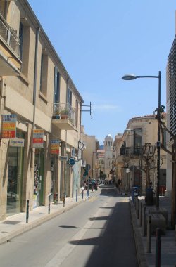 Limasol, Kıbrıs, 12 Nisan 2019: Eski kentte dükkanlar, kilise ve güneşli bir günde yürüyen insanlar ile sokak