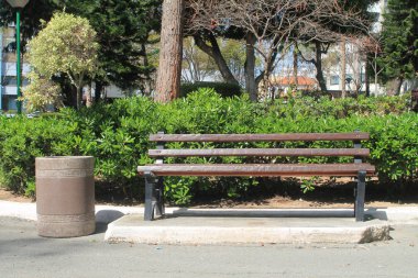 Bir bahar güneşli bir günde halka açık bir parkta boş ahşap bank