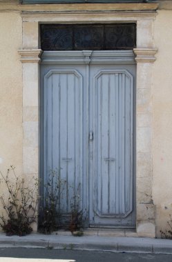 Kapı eşiğinde insan el şeklinde tokave kır çiçekleri ile eski moda mavi ahşap ön kapı 