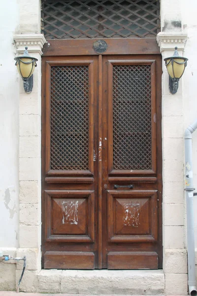 Staromodne Ciemnobrązowe Drewniane Drzwi Przednie Białym Kamiennym Ścianie Kratami Metalowymi — Zdjęcie stockowe