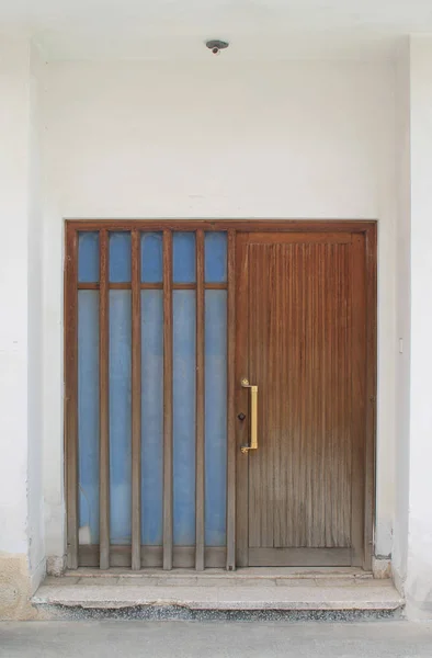 Brązowe Drewniane Drzwi Przednie Uchwytem Mosiądzu Białym Kamiennym Ścianie — Zdjęcie stockowe