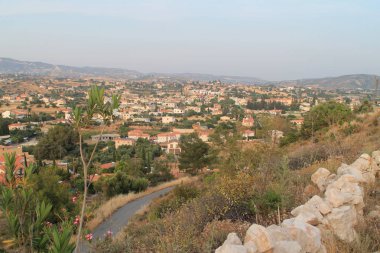 Boş bir yolun, bir Akdeniz köyünün, dağların ve gökyüzünün bir tepenin tepesinden alacakaranlıkta panoramik görünümü