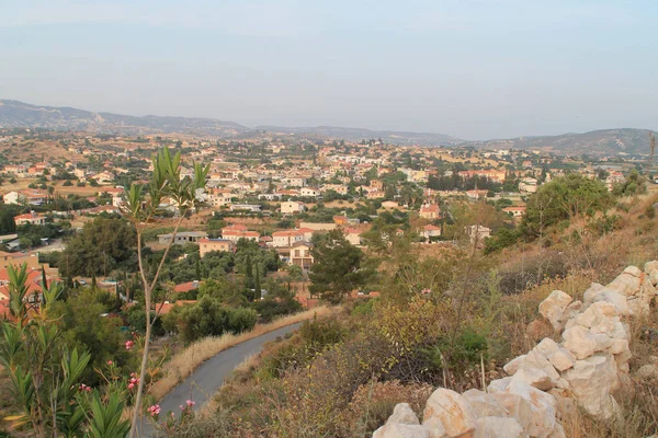 Panoramic view of an empty road, a mediterranean village, the mountains and the sky in twilight from the top of a hill